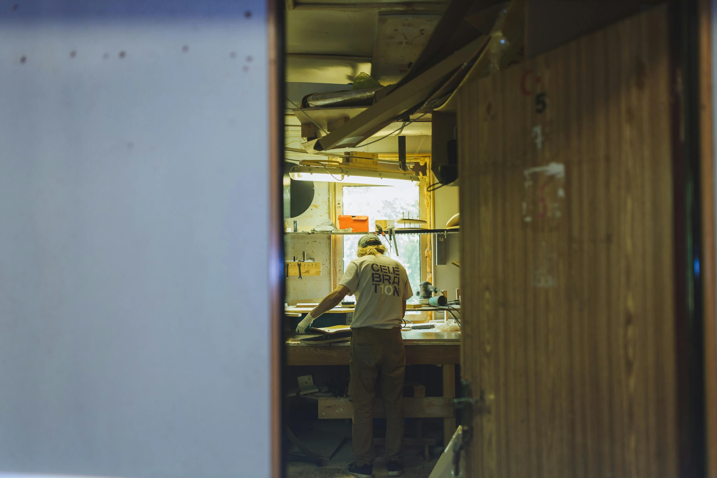 a man that is standing in a kitchen, a silk screen, unsplash, private press, inside a shed, back rooms, dingy, shot from a distance