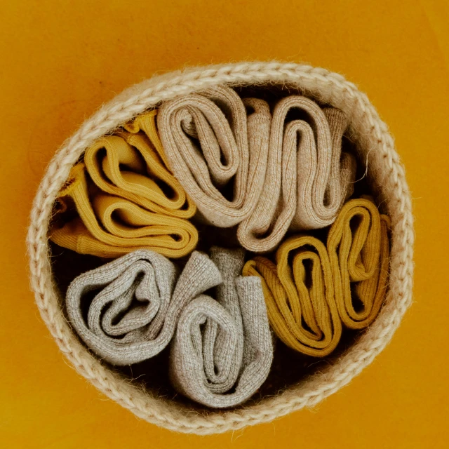 a basket filled with lots of different colored socks, pexels, silver and yellow color scheme, clay material, two - tone, felt!!! texture