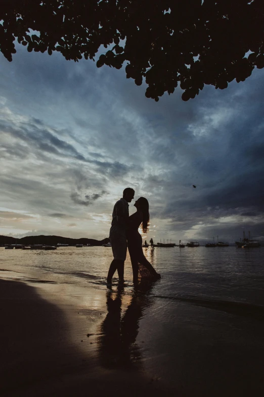 a couple kissing on the beach at sunset, a picture, unsplash contest winner, standing on a beach in boracay, rain lit, ground level shot, photography”