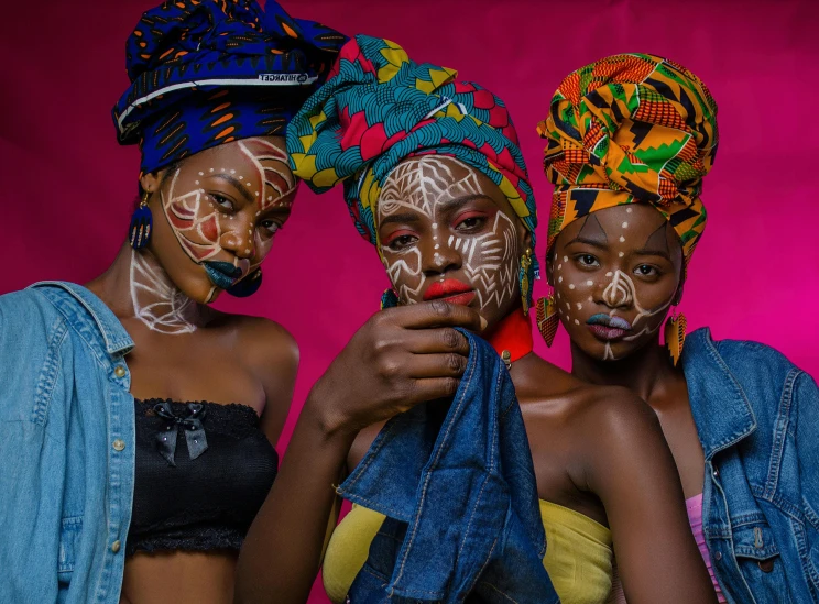 three women with painted faces pose for a picture, by Ingrida Kadaka, pexels contest winner, afrofuturism, bandanas, (beautiful) girl, beautiful female