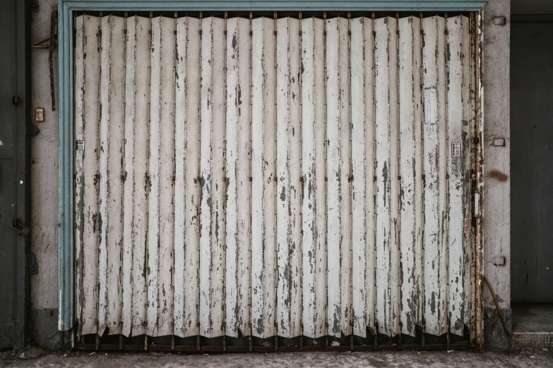 a closed garage door on the side of a building, inspired by Andreas Gursky, unsplash, weathered, background made of big curtains, rolf klep, white metal