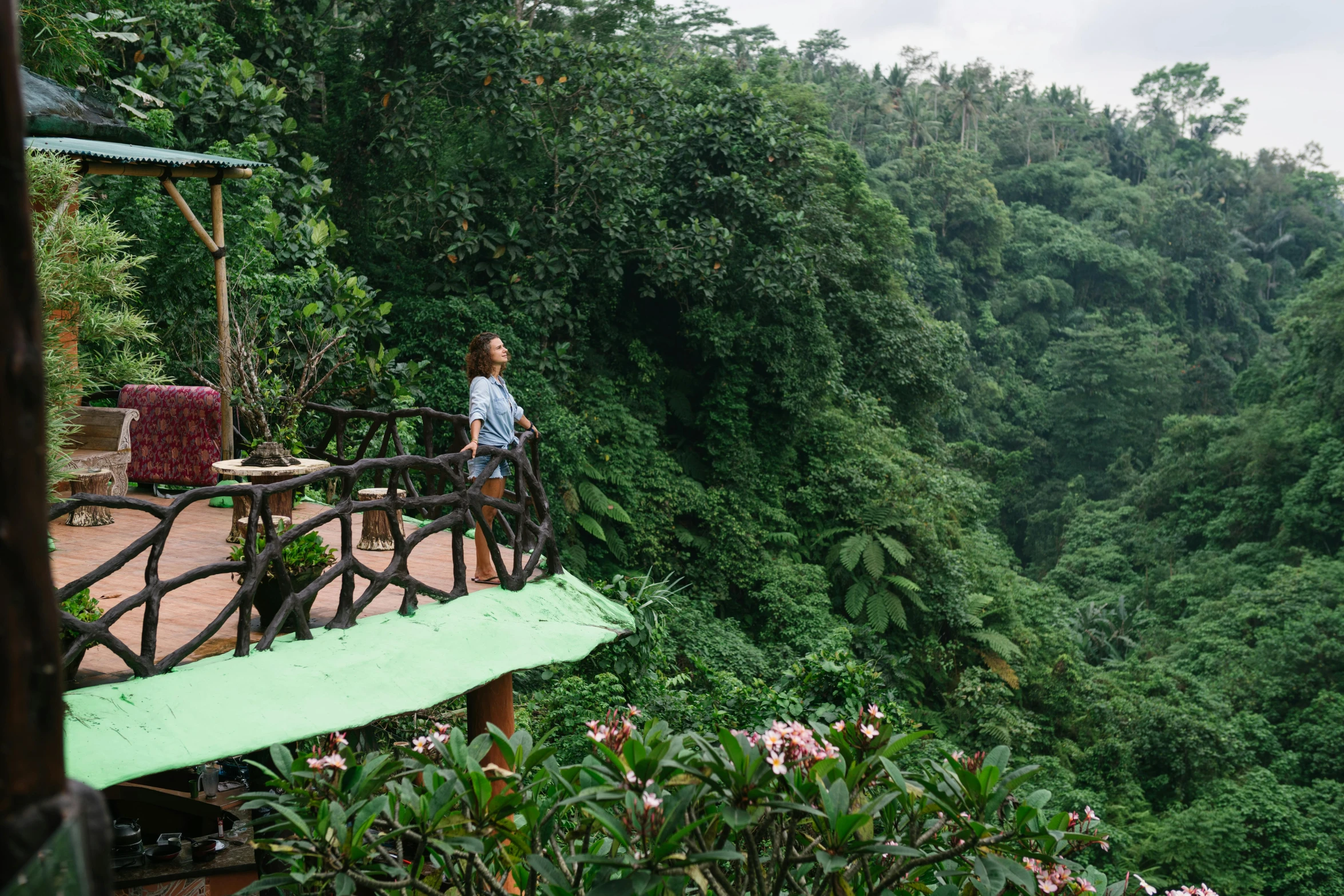 a woman standing on top of a wooden bridge, by Julia Pishtar, sumatraism, lush forest in valley below, avatar image