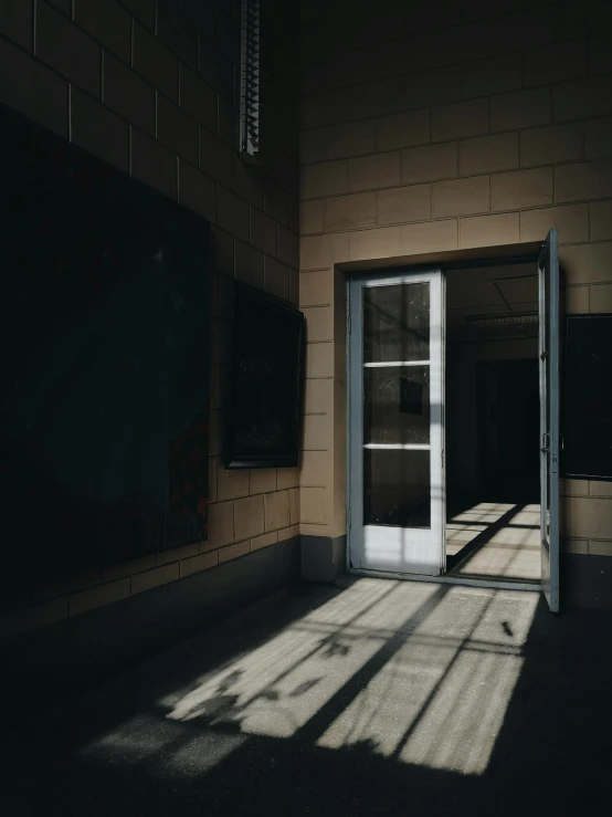 an empty room with a door and a window, inspired by Elsa Bleda, unsplash contest winner, strong shadows), in school hallway, dramatic light 8 k, trending on vsco