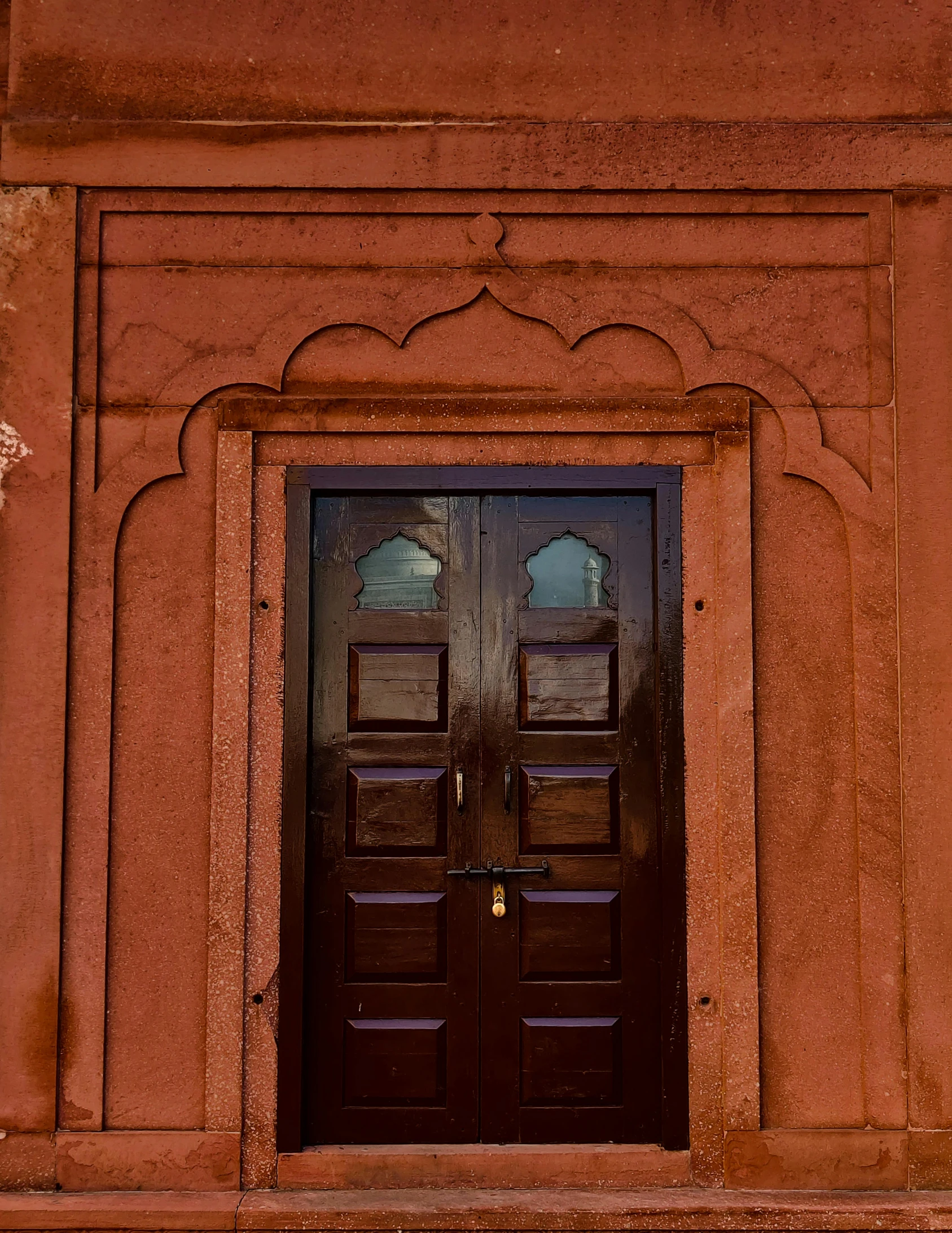 a fire hydrant sitting in front of a brown door, by Peter Churcher, pexels contest winner, arts and crafts movement, painting of mehrangarh fort, brown:-2, red sand, symmetrical doorway