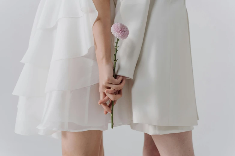 a couple of women standing next to each other, trending on pexels, aestheticism, white flower, wearing a white dress, background image, thighs close up