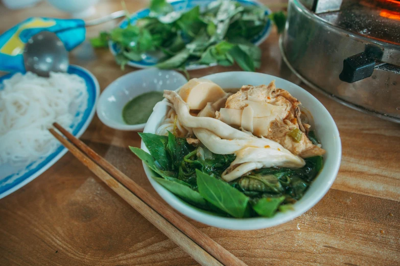 a wooden table topped with bowls of food and chopsticks, inspired by Tan Ting-pho, pexels contest winner, sea - green and white clothes, square, chicken, thumbnail