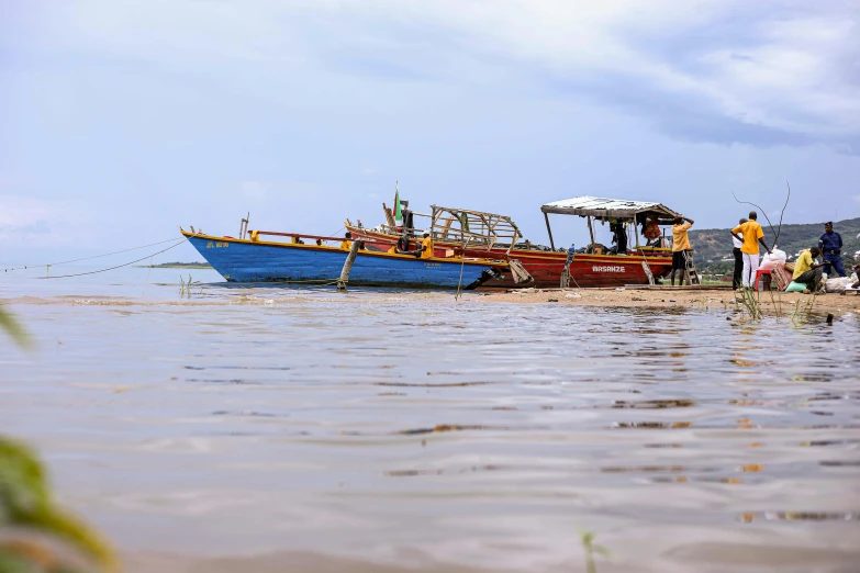 a red and blue boat sitting on top of a body of water, hurufiyya, thumbnail, cambodia, profile image, ground level shot