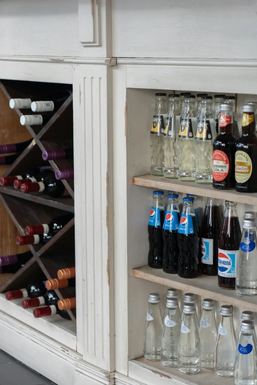 a bunch of bottles that are on a shelf, cabinets, drinks, up-close, upcycled