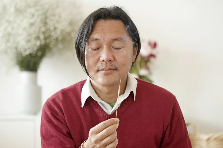 a man sitting at a table with a plate of food, shin hanga, incense, profile image, caring fatherly wide forehead, acupuncture treatment