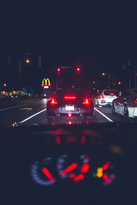 a number of cars on a city street at night, by Josh Bayer, pexels contest winner, realism, inside of a car, tail lights, awkward, fast food