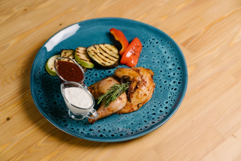 a blue plate topped with meat and vegetables, rooster, grey, thumbnail, exterior shot