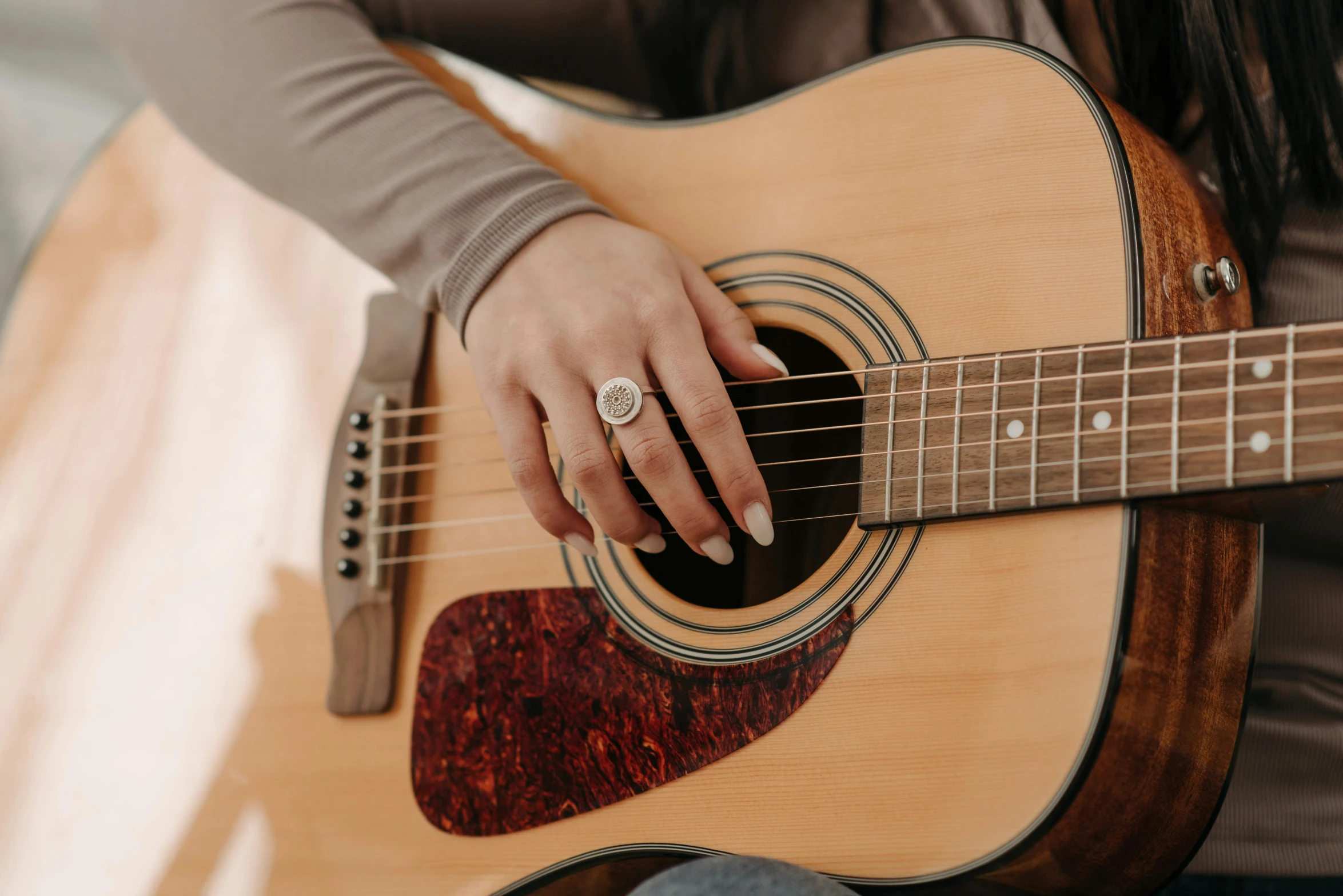 a close up of a person holding a guitar, by Winona Nelson, trending on pexels, point finger with ring on it, linsey levendall, slightly tanned, rectangle