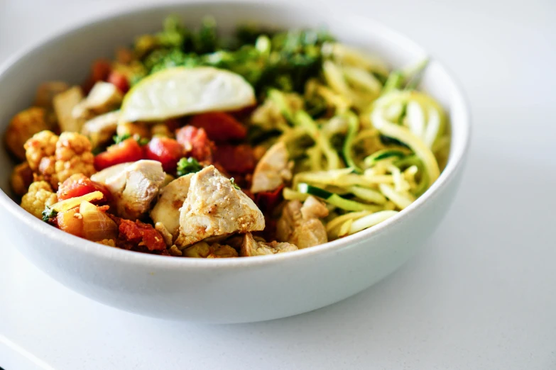 a close up of a bowl of food on a table, by Carey Morris, pexels, with a white background, chicken, veggies, ariel perez