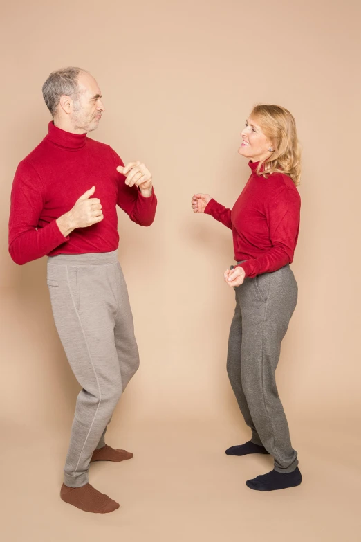 a man and a woman standing next to each other, inspired by Graham Forsythe, red sweater and gray pants, bendover posture, model photograph, tailored clothing