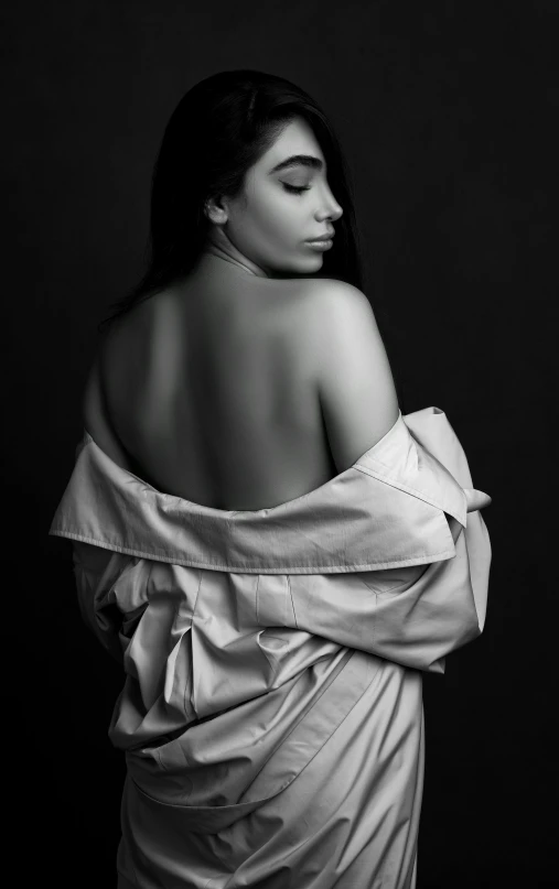 a black and white photo of a woman wrapped in a blanket, unsplash, conceptual art, portrait of demi rose, showing her shoulder from back, portrait of vanessa morgan, 15081959 21121991 01012000 4k