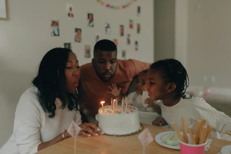 a group of people sitting around a table with a cake, profile image, candles, portrait featured on unsplash, parental advisory