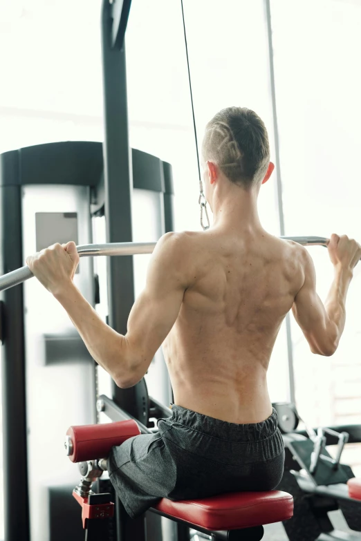 a man sitting on a bench in a gym, poster art, by Adam Marczyński, shutterstock, showing her shoulder from back, pulling strings, emaciated, instagram picture