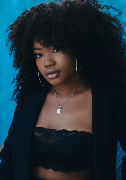 a woman with curly hair posing for a picture, an album cover, trending on pexels, black jewelry, vannessa ives, soft portrait shot 8 k, black teenage girl