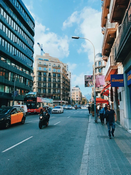 a group of people walking down a street next to tall buildings, in spain, 🚿🗝📝, trending on vsco, thumbnail