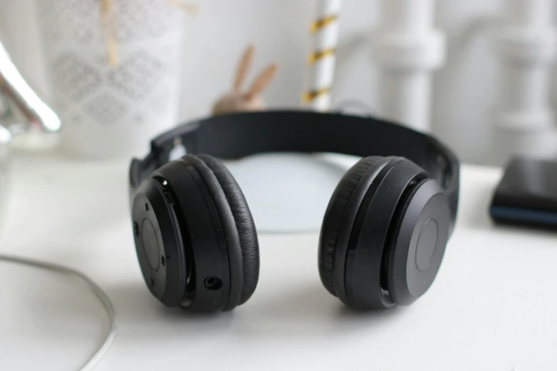 a pair of headphones sitting on top of a table, wearing black headphones, multiple stories, highly upvoted, ecommerce photograph