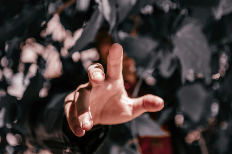 a person making a peace sign with their hands, an album cover, trending on pexels, a black cloak, close-up fight, low angle photography, avatar image