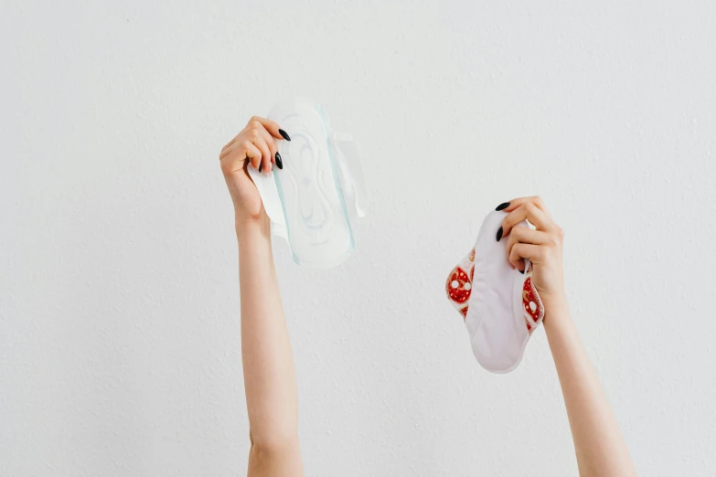 a woman holding a pair of socks up in the air, by Julia Pishtar, plasticien, soft pads, two women, transparent, contracept