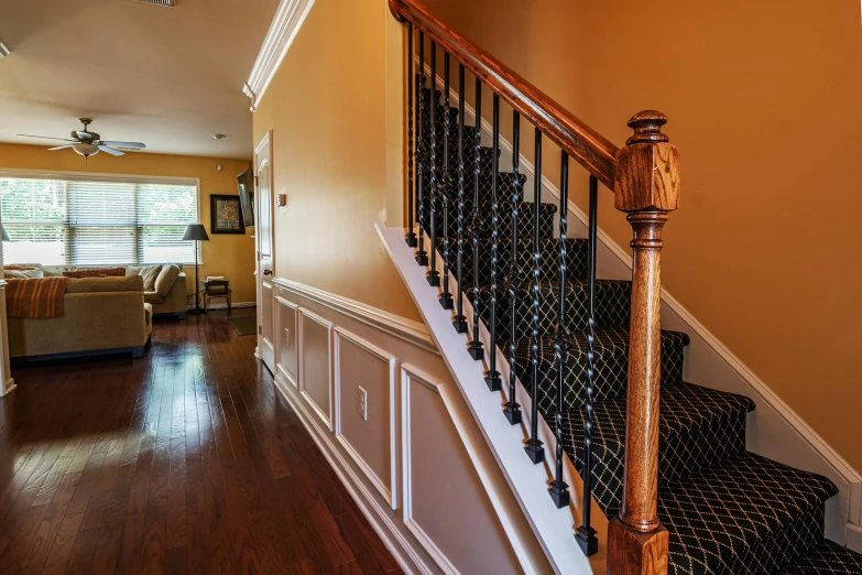 a staircase leading to a living room in a house, by Carey Morris, unsplash, highly detail wide angle photo, yellow and black trim, intricate detailed 8 k, real estate photography