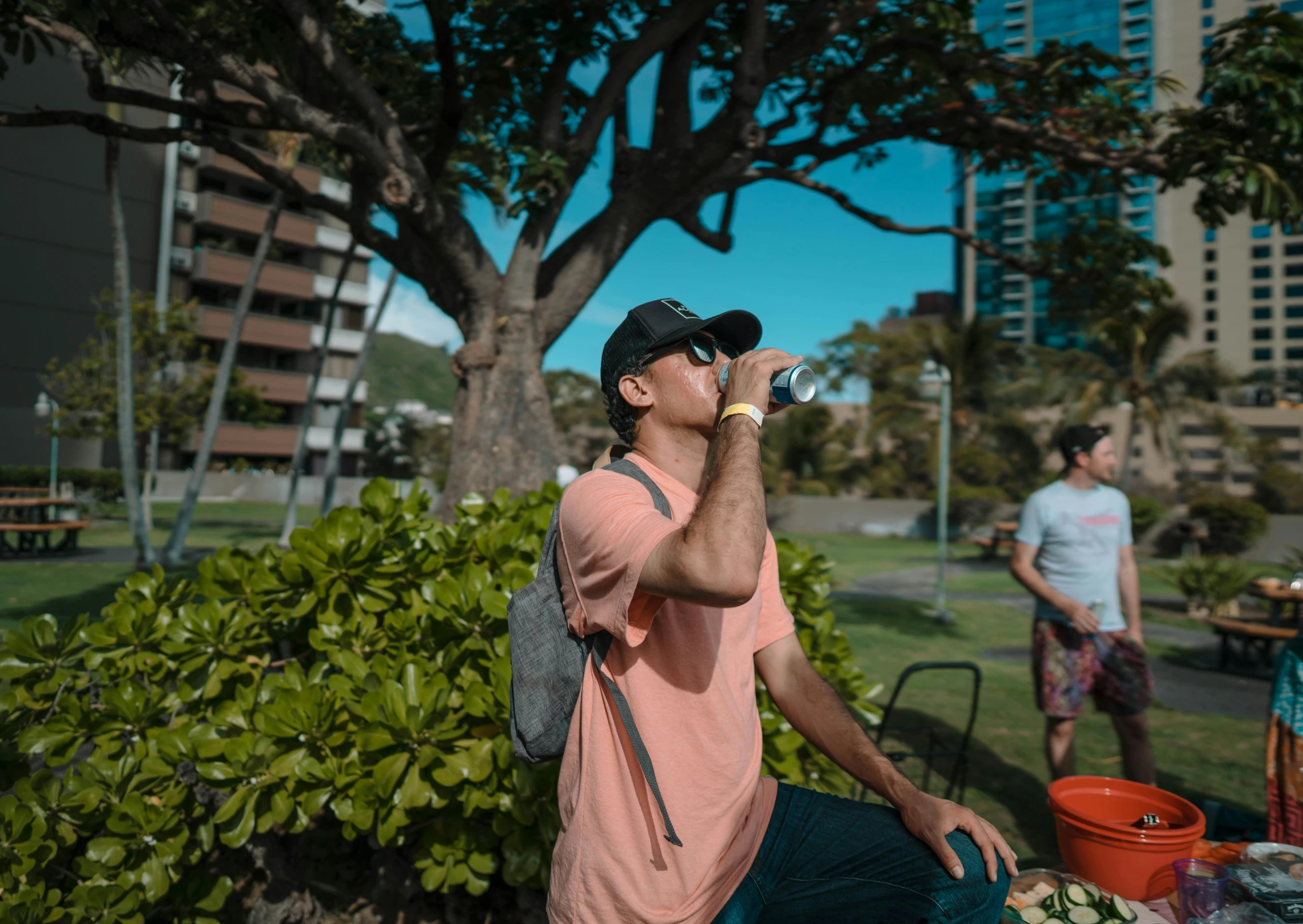 a man sitting on a bench drinking from a water bottle, a photo, by Drew Tucker, pexels contest winner, happening, posing in waikiki, avatar image, people on a picnic, wearing sunglasses and a cap