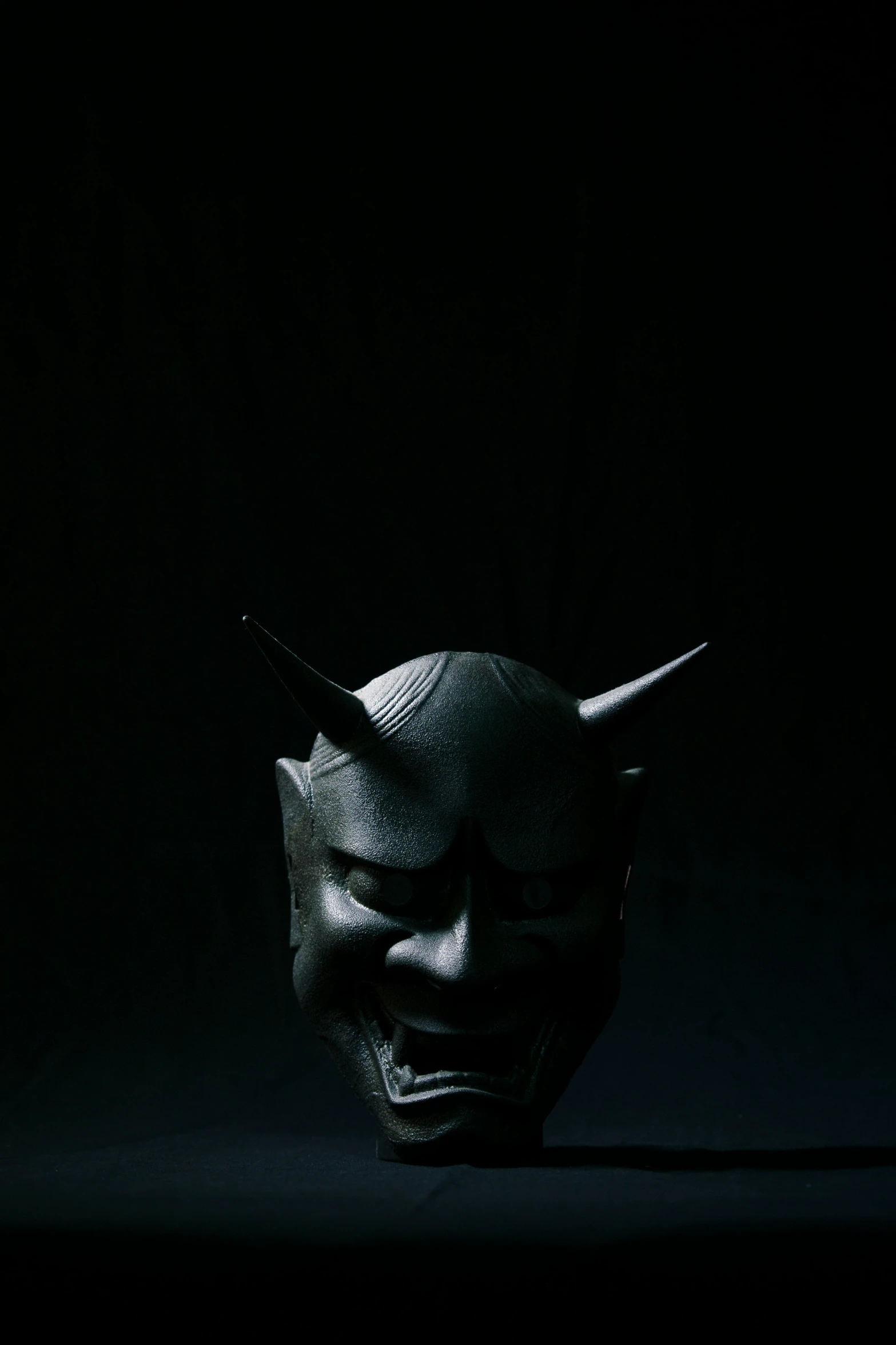 a black mask with horns sticking out of it, an album cover, trending on cgsociety, sōsaku hanga, japanese vfx, photographed for reuters, dark knight, anato finnstark. front view