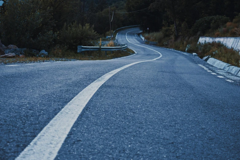 a man riding a skateboard down a curvy road, by Carey Morris, unsplash contest winner, photorealism, blue veins, hilly road, spooky photo, 2 5 6 x 2 5 6 pixels