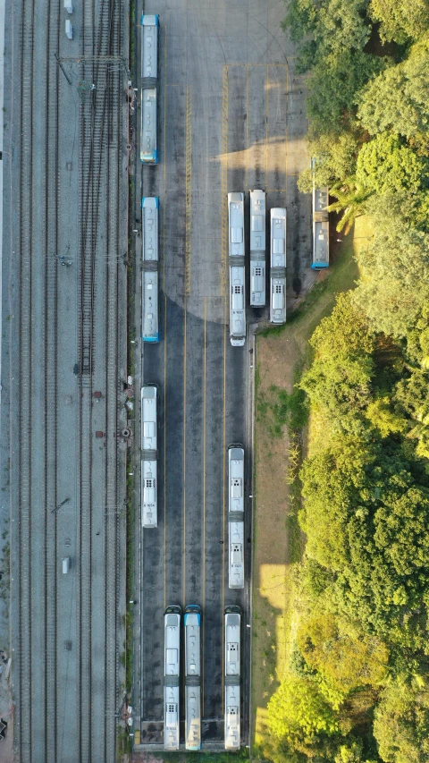 a train yard filled with lots of train tracks, by Joe Stefanelli, pexels contest winner, realism, satellite imagery, buses, shot on iphone 1 3 pro, a park