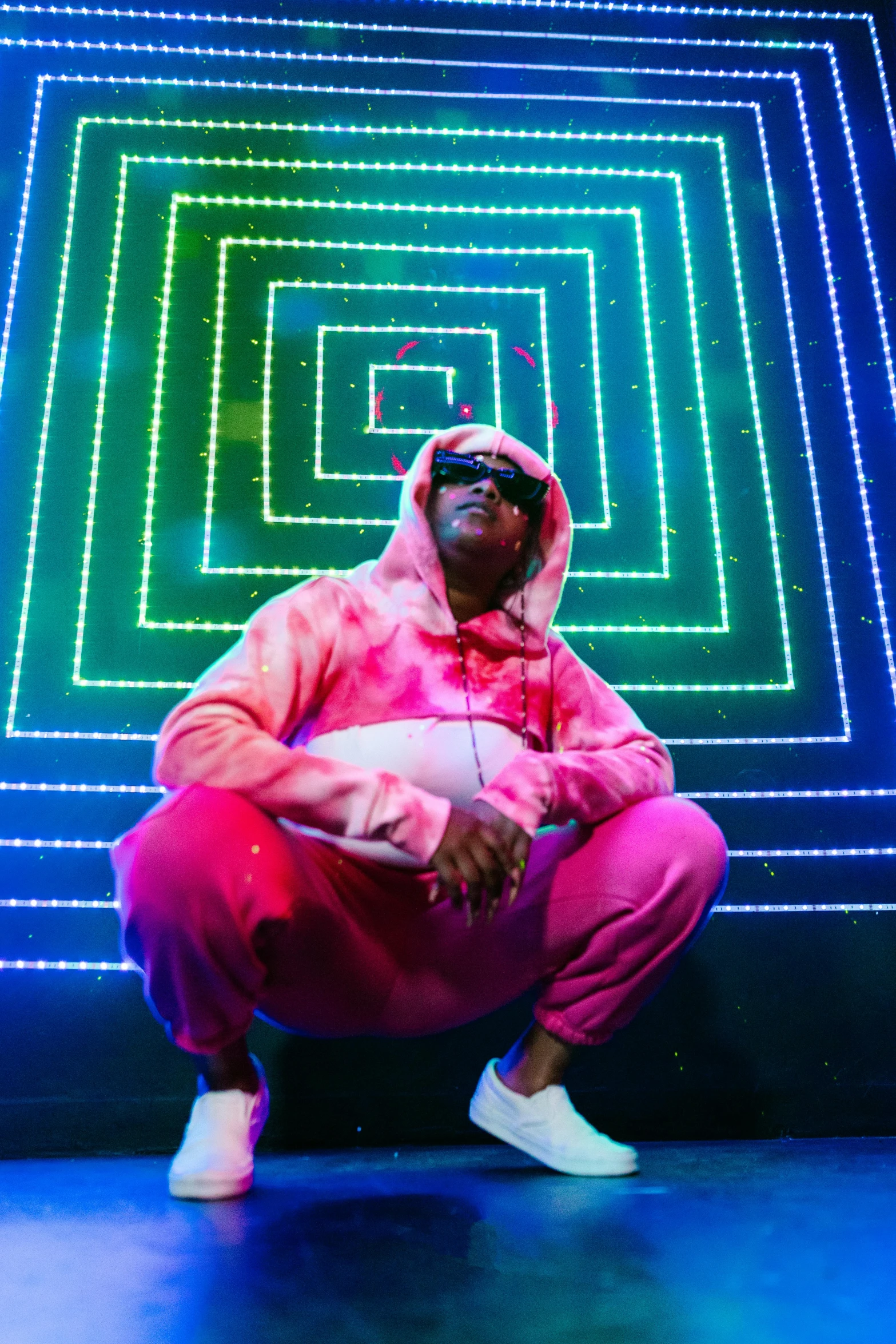 a man sitting in front of a neon square, an album cover, pexels, holography, wearing a plug suit, samuel jackson, hip hop aesthetic, light show