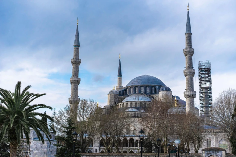 a group of people standing in front of a large building, inspired by Altoon Sultan, pexels contest winner, hurufiyya, blue and grey, dome, seen from afar, lead - covered spire