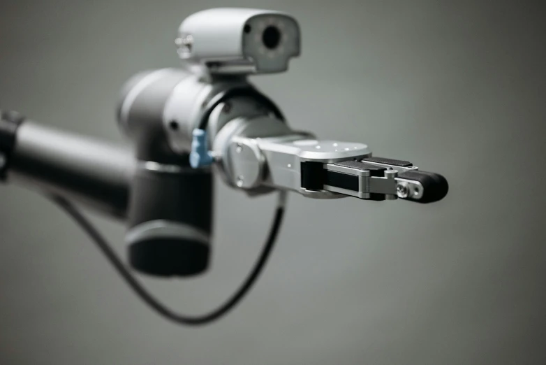 a camera attached to the handle of a bike, a microscopic photo, by Adam Marczyński, unsplash, bauhaus, humanoid robot close up, on grey background, robotic left arm, photographed for reuters