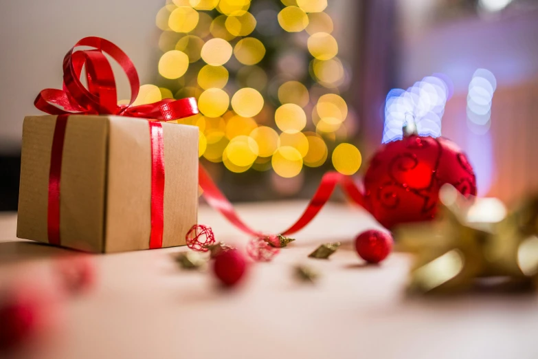 a present sitting on top of a table next to a christmas tree, pexels contest winner, red ribbon, avatar image, close up photograph, morning lighting