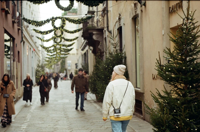 a group of people walking down a street next to tall buildings, an album cover, by Giuseppe Avanzi, pexels contest winner, renaissance, holiday, italian looking emma, taken with a disposable camera, a cozy