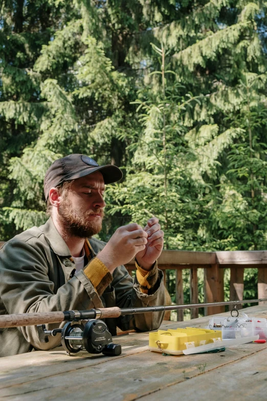 a couple of men sitting at a wooden table, wearing a fisher 🧥, sitting in the forrest, feeds on everything, maintenance