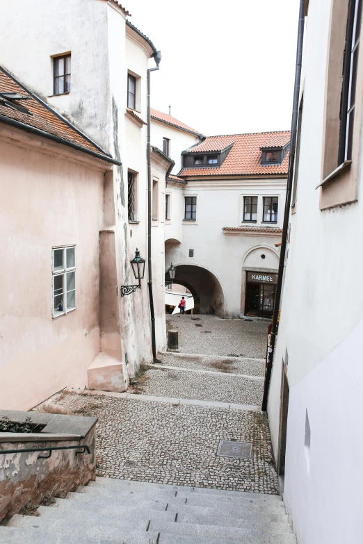 a couple of buildings that are next to each other, a picture, inspired by Mihály Munkácsy, small path up to door, massive arch, looking down on the camera, old town