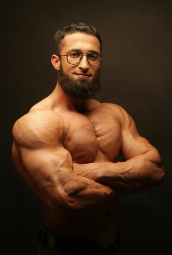 a man with a beard and glasses posing for a picture, an album cover, by Ahmed Yacoubi, pexels contest winner, hyperrealism, ifbb fitness body, big shoulders, stacked, feminine and muscular
