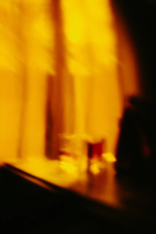 a blurry photo of a table in front of a window, inspired by Nan Goldin, ( ( abstract ) ), drinking at the bar, yellow, fiery