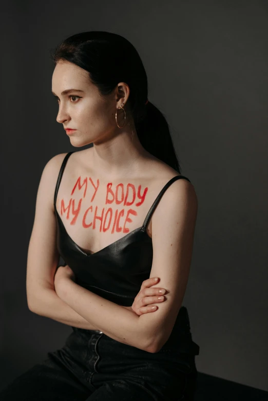 a woman with red writing on her chest, inspired by Vanessa Beecroft, trending on pexels, carice van houten, krysten ritter, cut out, concerned