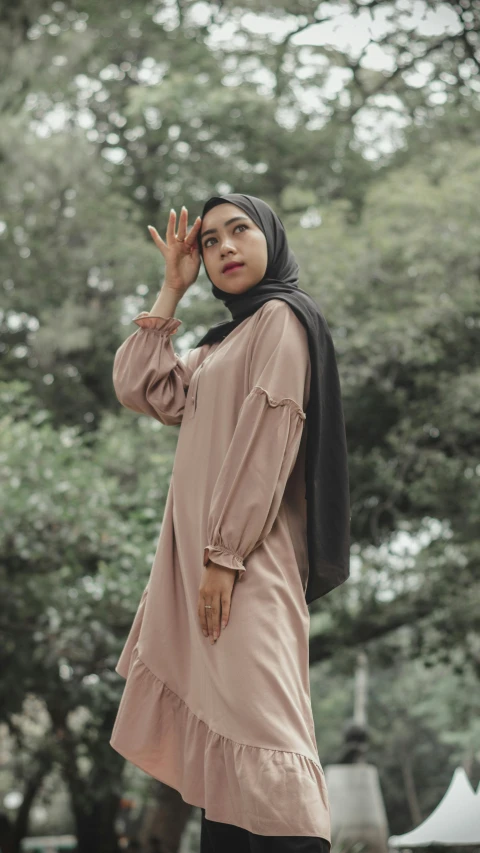 a woman in a hijab poses for a picture, inspired by Nyuju Stumpy Brown, trending on pexels, hurufiyya, tunic, light brown, thumbnail, high quality photo