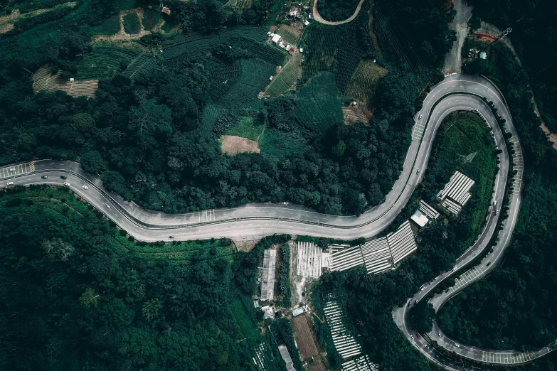 an aerial view of a winding road in the mountains, by Alejandro Obregón, pexels contest winner, happening, background: assam tea garden, bird's eye view of a city, race track background, thumbnail
