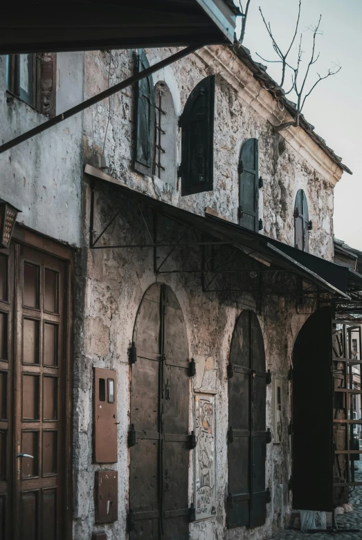 an old building sitting on the side of a road, pexels contest winner, renaissance, aged and weathered, many doorways, market, exterior photo