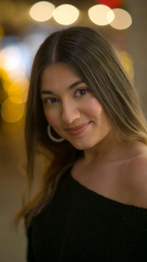 a woman in a black top posing for a picture, by Robbie Trevino, bokeh. chrome accents, portrait image, digital image, brown