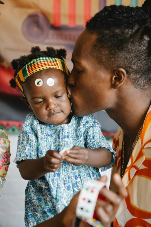 a woman kissing a small child on the cheek, trending on unsplash, afrofuturism, wearing an african dress, community celebration, slide show, caring fatherly wide forehead