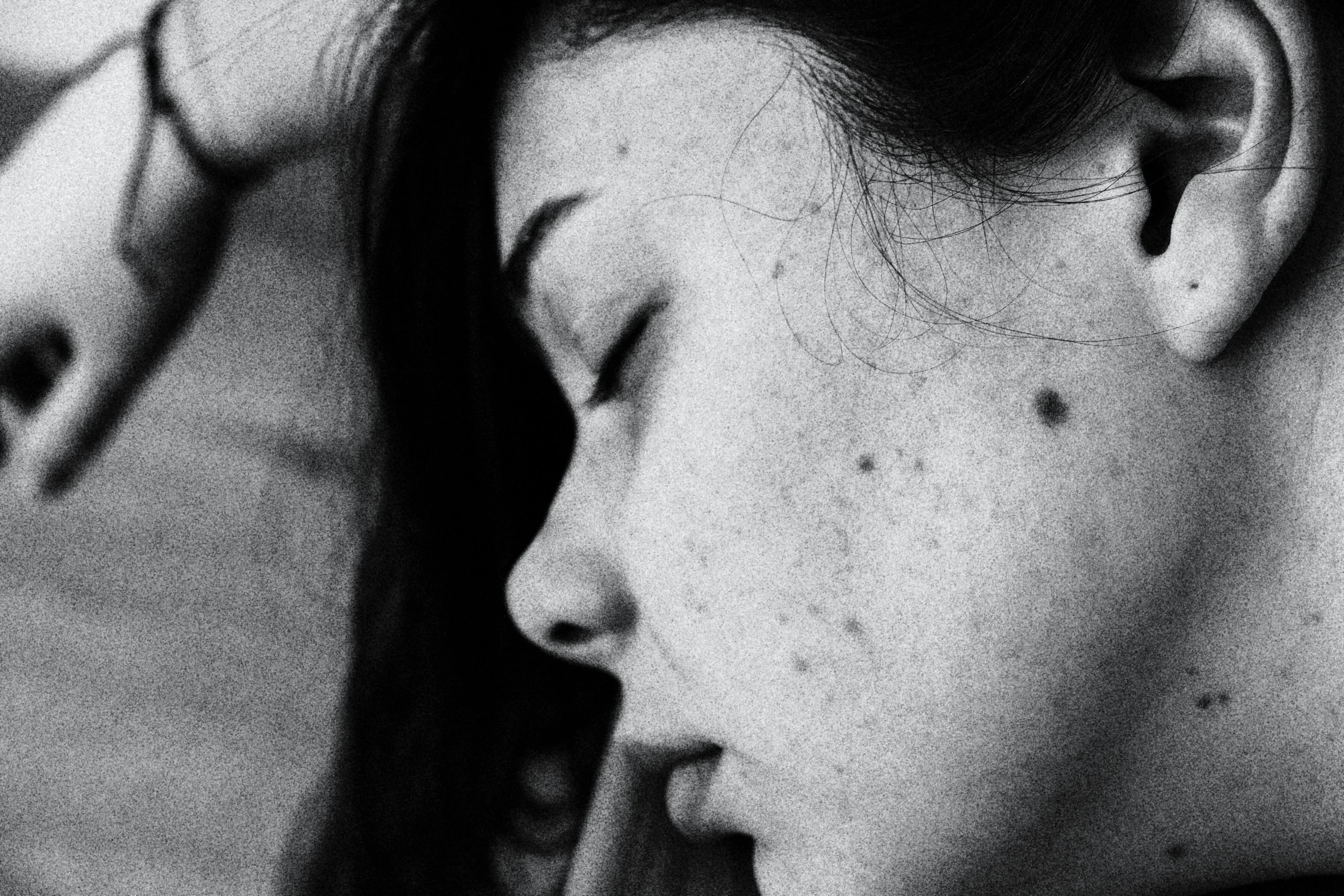 a black and white photo of a woman brushing her hair, inspired by Louis Faurer, tumblr, realism, portrait of a woman sleeping, freckles on the nose, detailed closeup face, girl with black hair