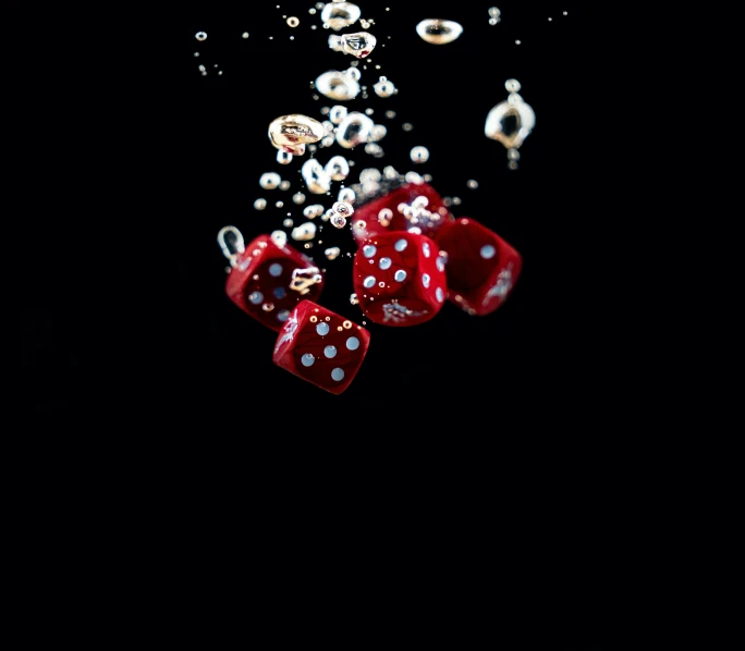 a couple of red dice sitting on top of a table, in the water, spores floating in the air, amoled wallpaper, instagram post