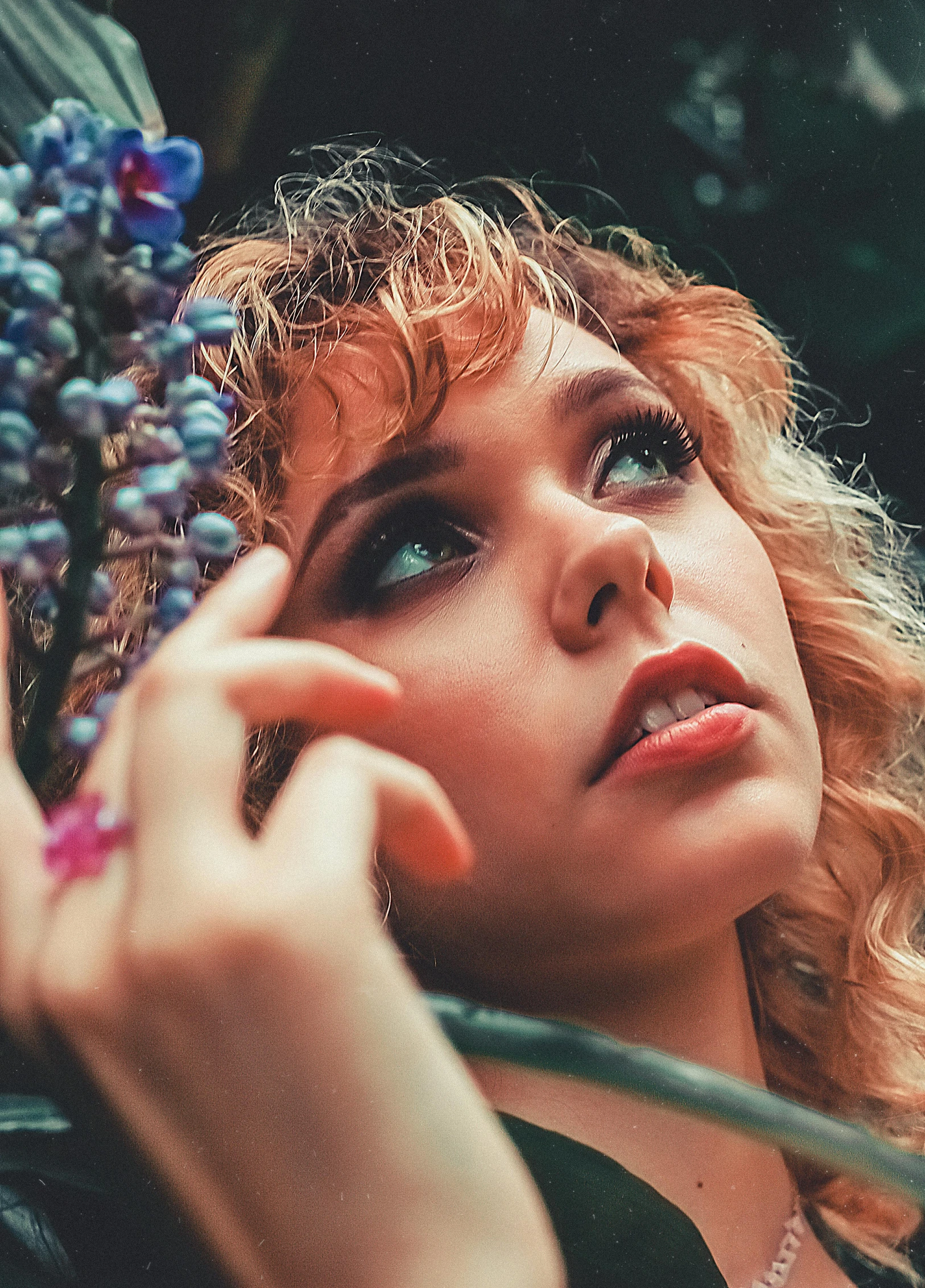 a woman holding a bunch of blue berries, a colorized photo, inspired by Elsa Bleda, pexels contest winner, magic realism, curly blonde hair | d & d, young woman looking up, a portrait of an elf, sophia lillis