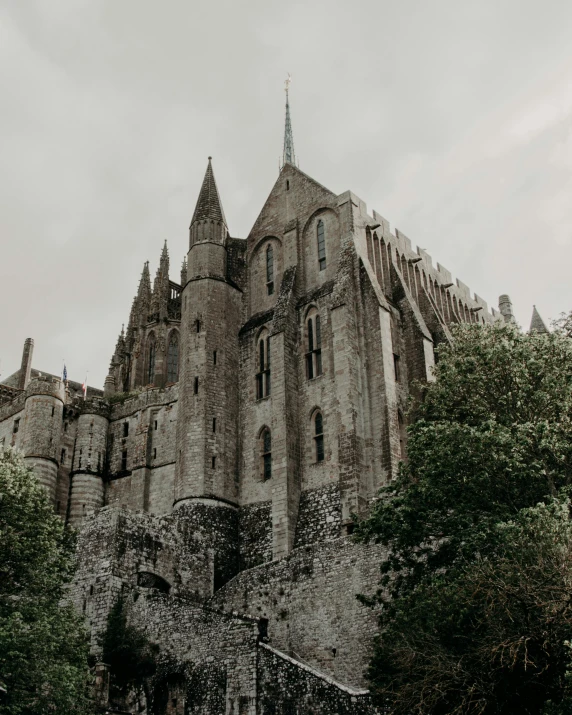 a large castle sitting on top of a lush green field, pexels contest winner, romanesque, dark gothic cathedral, 🎀 🧟 🍓 🧚, normandy, brutalist style